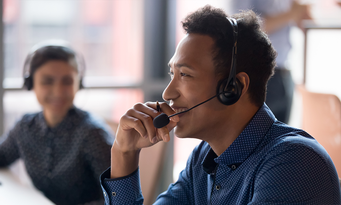 Man in an office setting wearing a headset.